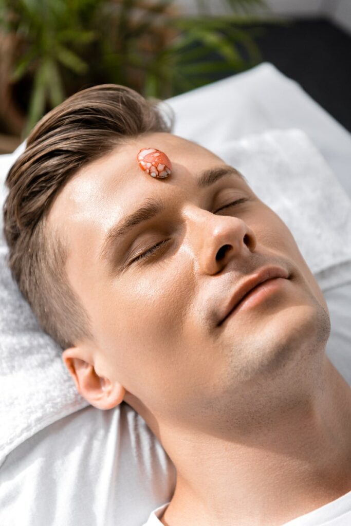 a man having crystal for emotional healing on his forehead